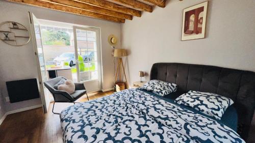 une chambre avec un lit, une chaise et une fenêtre dans l'établissement STNAHOME 60110 Maison Champêtre aux Portes de Paris, à Amblainville