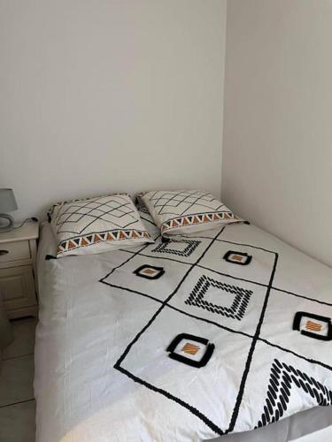 - un lit avec des draps et des oreillers en noir et blanc dans l'établissement Appartement avec vue sur la mer, à Fleury