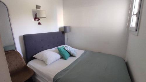 une petite chambre avec un lit et une chaise dans l'établissement T2 résidence avec piscine et tennis, à Bidart