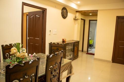a dining room with a table and a clock on the wall at Vara in Varanasi