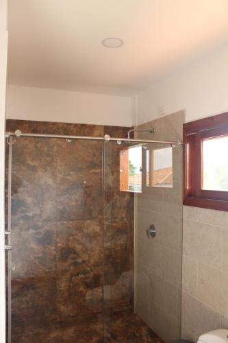 a bathroom with a shower with a glass door at Finca Hotel Casa Lupe En Santa Elena in El Cerrito