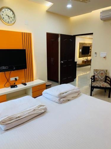 a bedroom with two beds and a tv on the wall at Vara in Varanasi