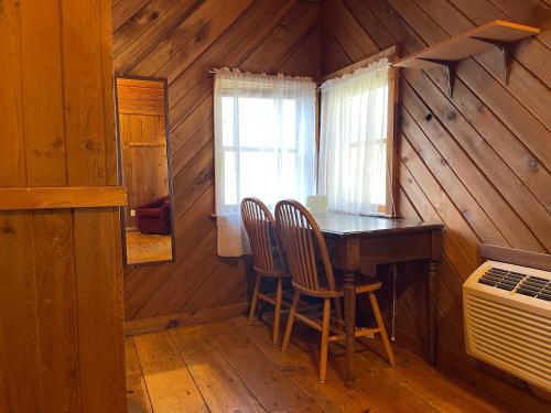 uma sala de jantar com uma mesa e cadeiras num camarote em Rhinebeck Village Inn em Rhinebeck