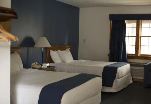 a hotel room with two beds and a window at Rhinebeck Village Inn in Rhinebeck