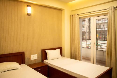 een kleine kamer met 2 bedden en een raam bij Vara in Varanasi