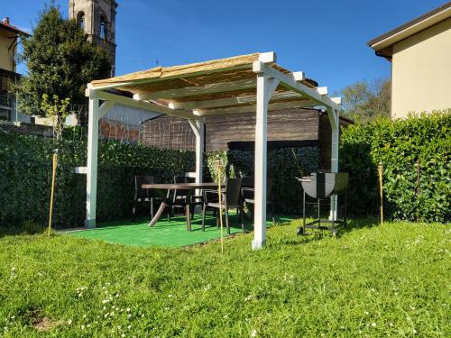 een houten pergola met een tafel in een tuin bij Aleksander' s House in Pontremoli