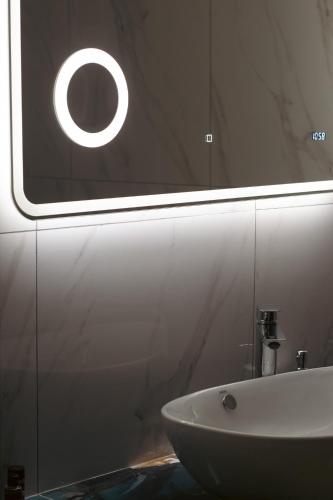 a bathroom with a white sink and a window at Emily Apartments 3 in Chrysoupolis
