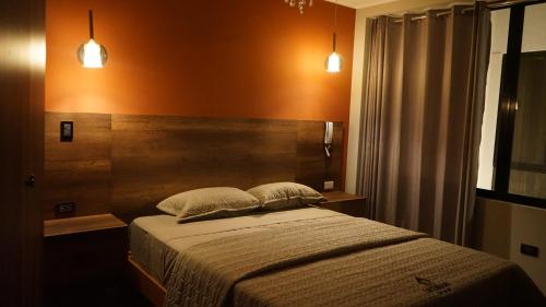 ein Schlafzimmer mit einem Bett mit zwei Kissen darauf in der Unterkunft Ukumari Hotel in Chachapoyas