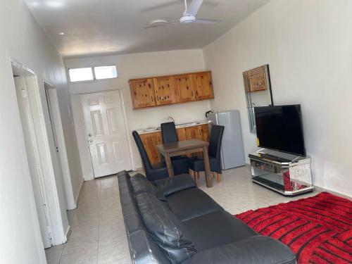 ein Wohnzimmer mit einem Sofa und einem TV in der Unterkunft Samba Tako Plaza Home Suites in Sukuta