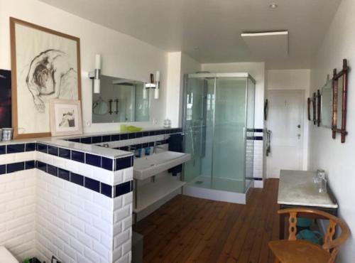 une salle de bain avec une douche en verre et un lavabo dans l'établissement La Valoiserie, charming Normandy manor near the sea, à Montfarville