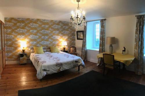 une chambre avec un lit, une table et une fenêtre dans l'établissement La Valoiserie, charming Normandy manor near the sea, à Montfarville