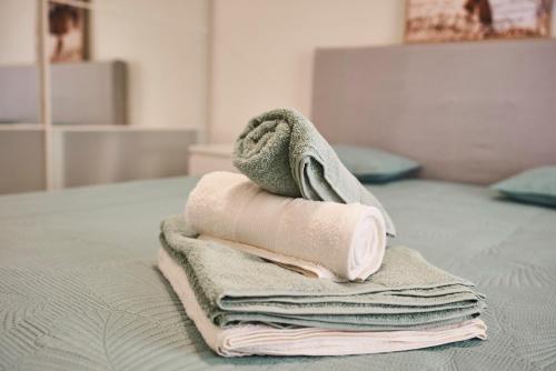 une pile de serviettes posée sur un lit dans l'établissement Moderne 2/3 Pièces près du Port, à Nice