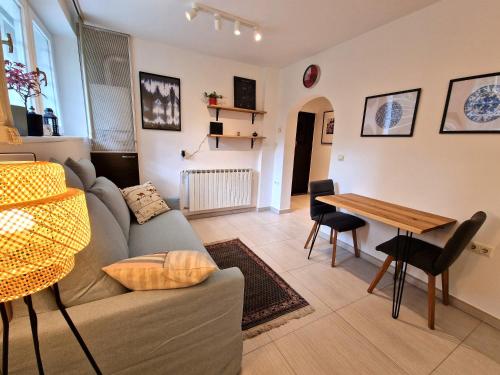 uma sala de estar com um sofá e uma mesa em Artistic Apartment in Center em Zagreb