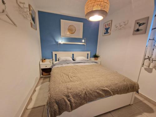 een slaapkamer met een bed met een blauwe muur bij Artistic Apartment in Center in Zagreb