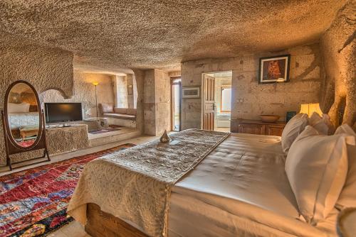 a bedroom with a large bed and a living room at Glamada Cave Suites in Urgup
