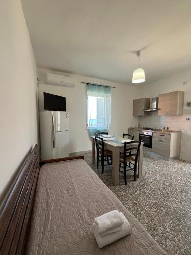 a room with a bed and a kitchen with a table at Vista Mare in Torre San Gennaro