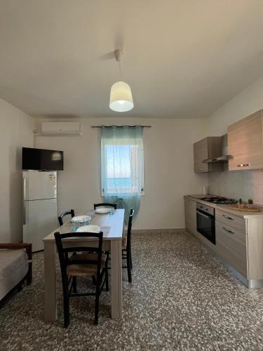 a kitchen and dining room with a table and chairs at Vista Mare in Torre San Gennaro