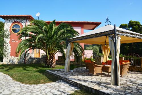 a patio with an umbrella in front of a house at Petros Italos in Neos Marmaras