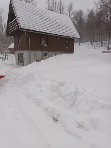 a house covered in snow in front at Koliba Japa in Delnice
