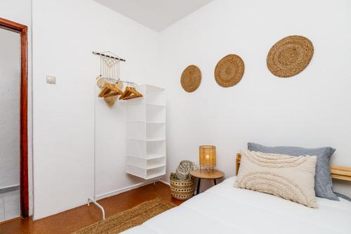 ein Schlafzimmer mit einem Bett und Körben an der Wand in der Unterkunft MADA HOUSE's II in Sesimbra
