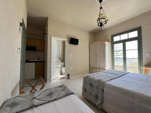 a large bedroom with two beds and a kitchen at Kores Aegina in Agia Marina Aegina