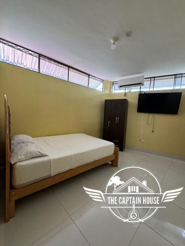 um quarto com uma cama e uma televisão num quarto em The Captain House em Pucallpa