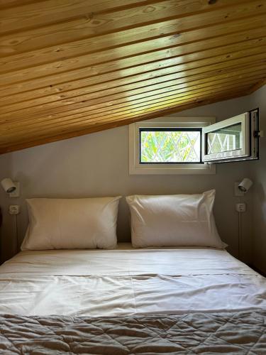Bett in einem Schlafzimmer mit Holzdecke in der Unterkunft Antonis's Garden House in Athen