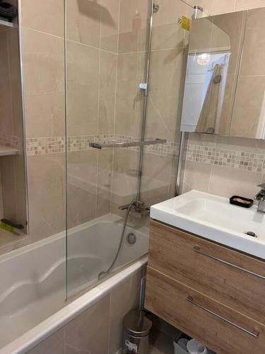 une salle de bain avec une douche, une baignoire et un lavabo dans l'établissement Super 3 pcs et Parking aux portes de Paris et stade de france à proximité des sites touristiques parisiens Montmartre , champs Élysée ,châtelet etc et des transports métro,RER ,wifi disponible, à Saint-Ouen