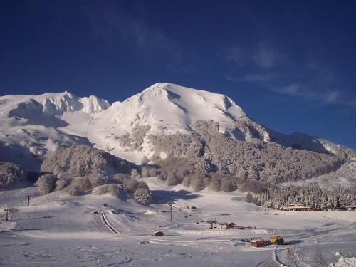 a snow covered mountain with a snow covered mountain at Chalet Vista Lago in San Gregorio