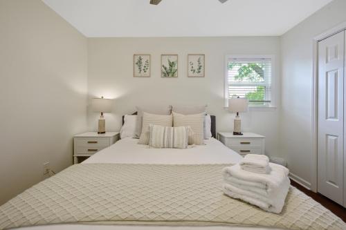 1 dormitorio blanco con 1 cama blanca y 2 lámparas en Downtown Hillsborough Duplex, en Hillsborough