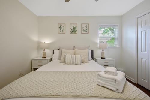 a white bedroom with a white bed and two lamps at Downtown Hillsborough Duplex in Hillsborough