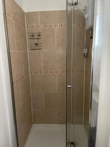 a shower stall with a glass shower door at Unique London Apartment, ideal for Long Stays in Finchley