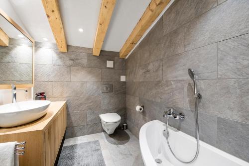 une salle de bain avec une baignoire, un lavabo et des toilettes dans l'établissement Rothornblick 65 by Arosa Holiday, à Arosa