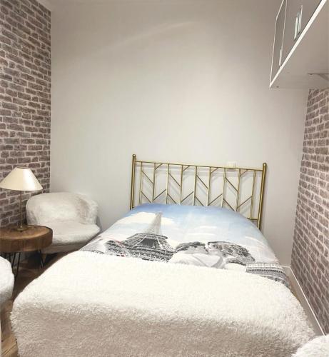 - une chambre avec un lit et une photo d'un bâtiment dans l'établissement Eiffel Tower studio with patio, à Paris