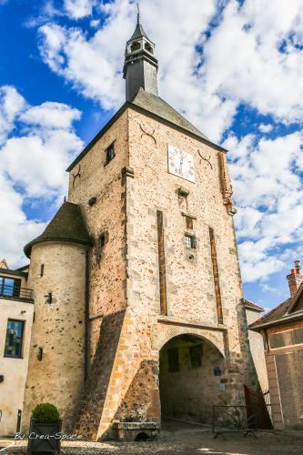a building with a clock on the top of it at Logis Hotel La Tourelle du Beffroi in Bourbon-Lancy