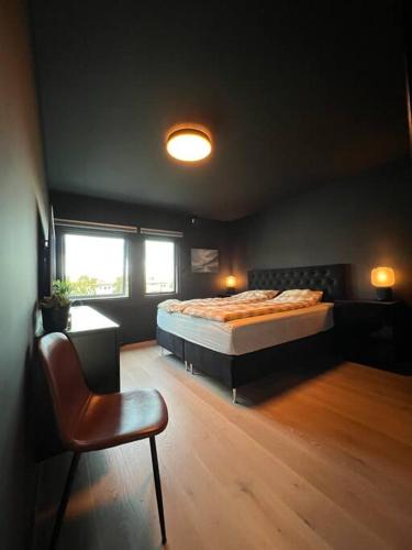 um quarto com uma cama e uma cadeira em Moderne leilighet med 2 soverom, 4 sengeplasser em Trondheim
