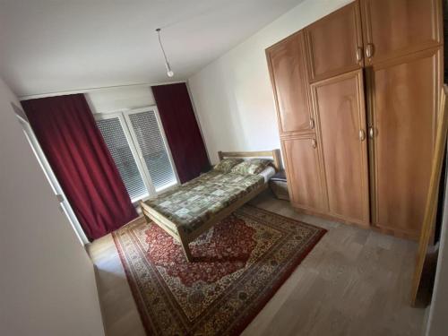 a small room with a bed and a rug at Banes me qera in Gjilan
