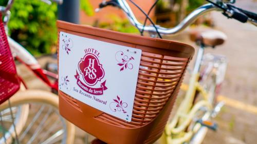 a basket on a bike with a sign on it at Hotel Recanto da Serra in Gramado
