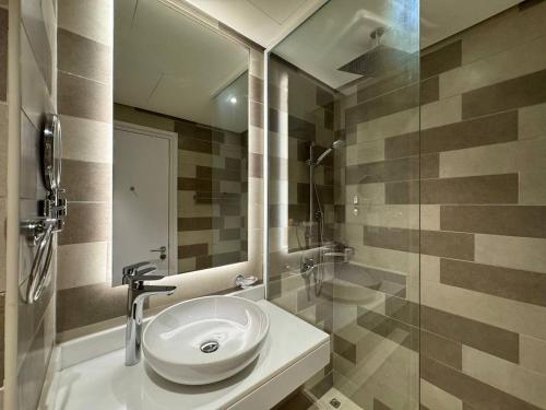 a bathroom with a sink and a glass shower at Seven Hotel & Apartments at the Palm Jumeirah Studio apartment with awesome view in Dubai
