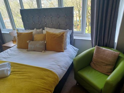 a bedroom with a bed and a green chair at Lovely 1-Bed Apartment in Birmingham in Birmingham