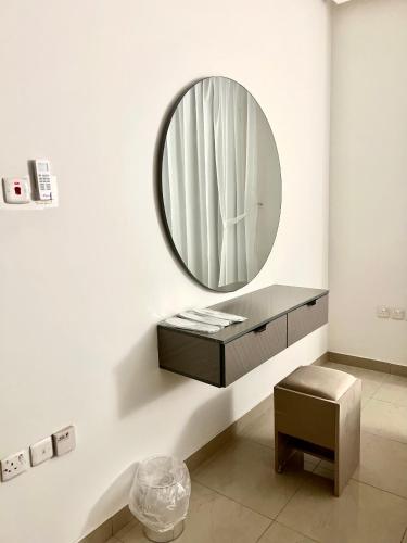 baño con espejo redondo y taburete en غرفة وصالة بدخول ذاتي, en Riad