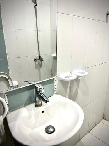 Baño blanco con lavabo y espejo en غرفة وصالة بدخول ذاتي, en Riad