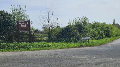 a sign on the side of a road next to a fence at Ultimate serene getaway in East Mersea