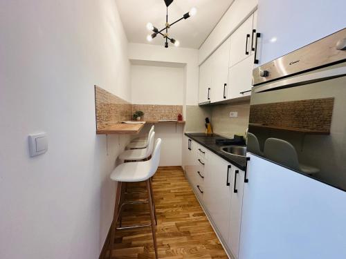 a small kitchen with white cabinets and a sink at Nirvana 06 in Zlatibor