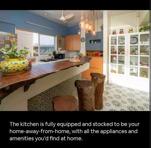 a kitchen with a counter and stools in it at Top-floor Oceanfront Designer Condo In Bandra in Mumbai