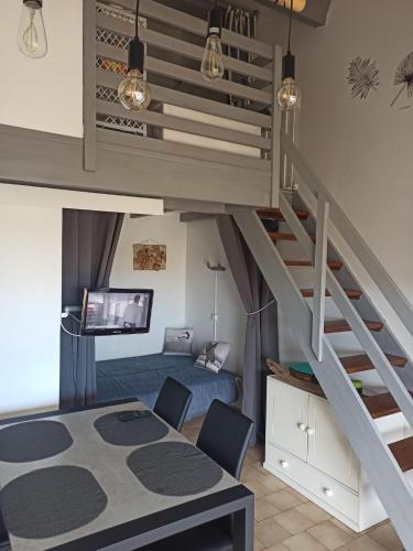 une chambre avec un lit superposé et un escalier dans l'établissement Hauts de Saint Pierre, à Saint Pierre La Mer