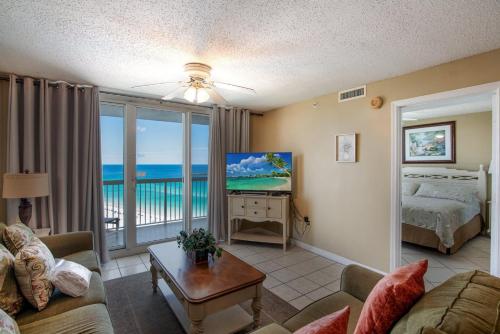 een woonkamer met een bed en uitzicht op de oceaan bij Pelican Beach 1612 condo in Destin