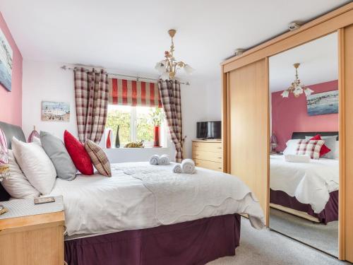 a bedroom with two beds and a large mirror at 14 Belvedere Court in Paignton