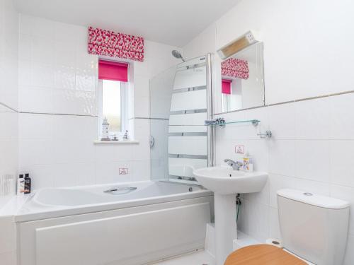 a white bathroom with a sink and a toilet at 14 Belvedere Court in Paignton