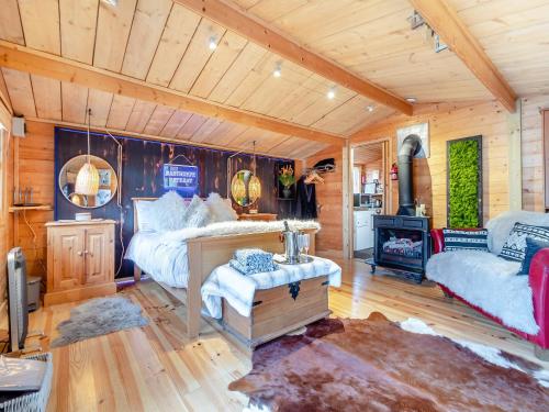 um quarto com uma cama, um sofá e uma lareira em Easthorpe Retreat em Copford